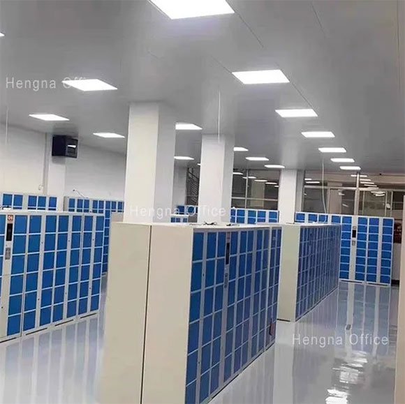 Full bank of blue face recognition lockers installed in factory showroom, demonstrating large-scale deployment capability with camera and keypad on each unit